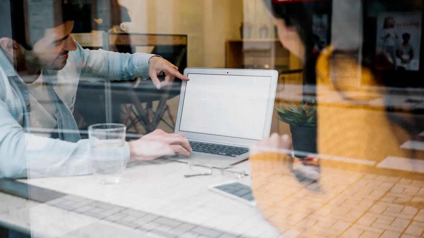 Пара смотрит на экран ноутбука.